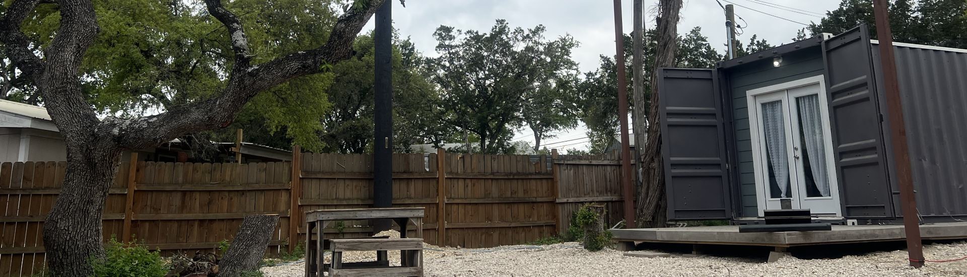 Converted shipping container into tiny home, painted gray with white trim