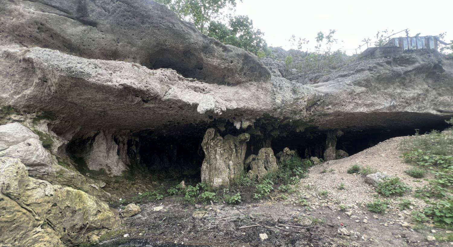 Open cave in the side of a rock with weather rock formations